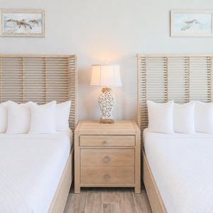 Stylish guest bedroom featuring two plush queen beds, charming and fun turtle decor, and soft lighting