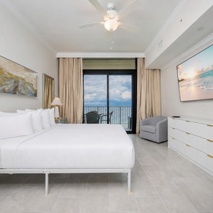 Relax in this inviting master suite featuring a king bed, stylish decor, and beachfront balcony access