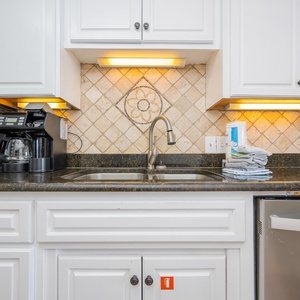 Warm lights illuminate the kitchen countertop where you brew your morning coffee and wash fresh fruit