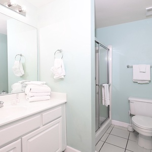 This bathroom features a clean design with a spacious vanity, fresh towels, and a glass shower, perfect for relaxation