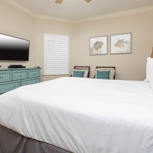 Unwind in this guest bedroom featuring a plush queen bed, stylish decor, and a TV for your entertainment