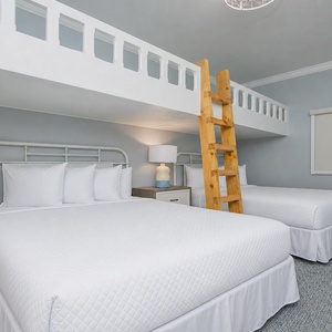 Relax in this charming guest room with cozy loft twin bunk beds over two cozy queens for a restful stay