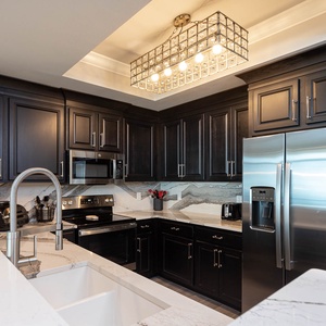 Cook and gather in this stylish kitchen with stainless appliances, elegant marbled tile, and rich cabinetry