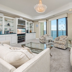 Unwind in this spacious living area, featuring plush seating, a glass coffee table, and stunning beach views