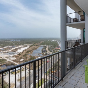 This balcony features vibrant green chairs, offering a serene view of the lush state park landscape below