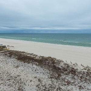 Tranquil shoreline with gentle waves and a wide stretch of beach, perfect for relaxation and exploration
