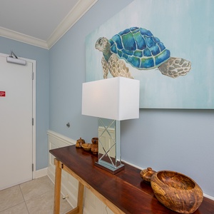 Step into a welcoming entryway adorned with coastal art, setting a serene mood for your beach getaway