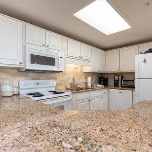 Prepare meals in the spacious kitchen featuring granite countertops, white appliances and Keurig coffee station