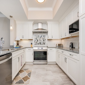 Prepare meals in this kitchen featuring granite countertops, upgraded appliances, and stylish decor