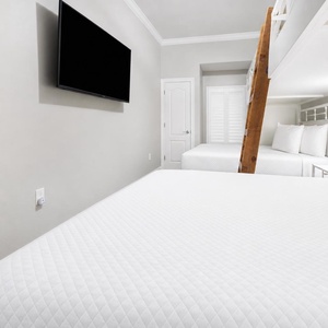 Unwind with a movie in this cozy bunk room with fun colors and two twins lofted above two queen beds