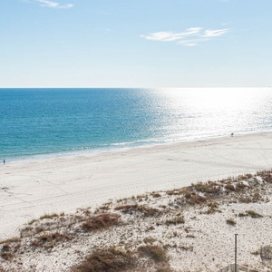 This breathtaking view showcases a tranquil beachfront, inviting guests to relax and enjoy the serene coastal atmosphere