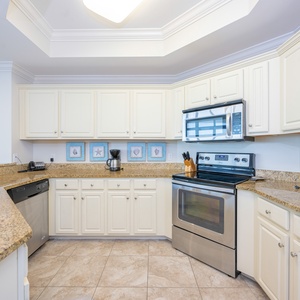 Kitchen featuring stainless appliances, granite countertops, coffee station, and coastal decor for a refreshing atmosphere