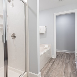 Step into the glass shower or sink into the bathtub, then wrap in a fresh towel in this master bath