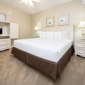 Unwind in this serene bedroom featuring a plush king bed, soft lighting, and a TV for your entertainment