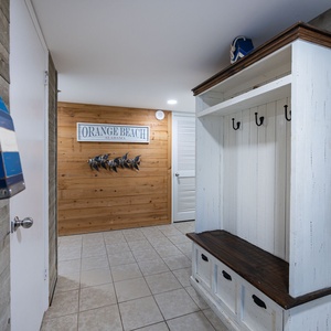 Step into a welcoming entryway featuring coastal decor, hooks for convenience, and a cozy bench for your beach gear