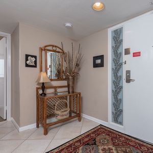 Welcoming entryway featuring a decorative console table, stylish lamp, and elegant wall art for a cozy atmosphere