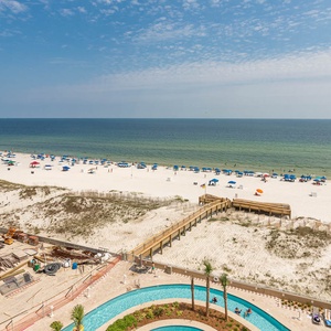 Stroll the wooden boardwalk, sense warm gulf air, and admire dozens of beach umbrellas tracing the shore