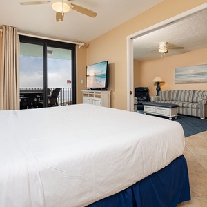 Calming master bedroom featuring a king bed, flat-screen TV, and access to the beachfront balcony