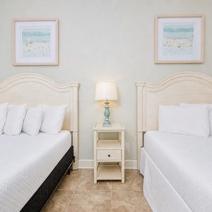 Inviting guest bedroom featuring two plush queen beds, elegant decor, and soft, neutral tones for a relaxing stay