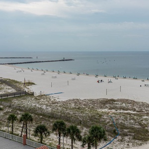 Enjoy the scenic view of the beach with lounge chairs and umbrellas, perfect for relaxation and sunbathing