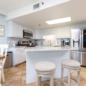 Bright kitchen featuring white cabinetry, granite countertops, and a breakfast bar, complemented by the dining area