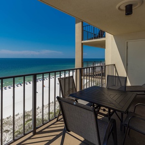 Relax on the balcony with a dining table and chairs, enjoying the beautiful beach view just steps away