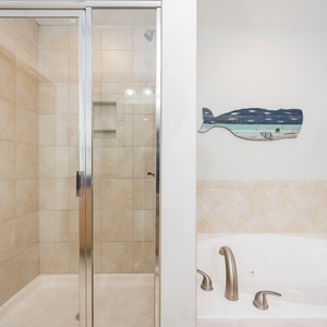 Indulge in relaxation with a spacious walk-in shower and a soothing jetted tub, complemented by beach decor