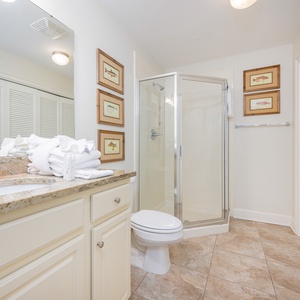Additional bath featuring a walk-in shower, granite countertops, laundry area with washer/dryer and charming fish artwork
