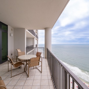 Relax on the spacious balcony with comfortable seating and breathtaking views of the tranquil shoreline