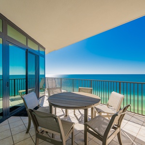 This balcony features a round table and six chairs, perfect for enjoying stunning beachfront views from the seventeenth floor