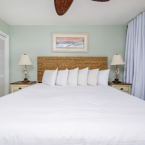 The master bedroom features a plush white bed with decorative pillows, soft green walls, and a cozy atmosphere for relaxation