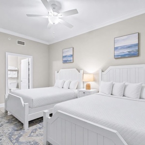 Rest in this cozy guest room with two queen beds, soft decor, and a warm atmosphere