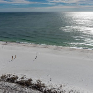 A serene view of a pristine beach and gentle waves, inviting relaxation and enjoyment of the coastal atmosphere