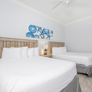 Guest bedroom featuring two cozy queen beds and beach-inspired decor for a relaxing getaway