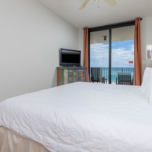 The master features a comfortable king bed and a view of the beach from the sliding glass doors leading to the balcony