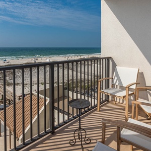 Enjoy breathtaking beachfront views from the cozy balcony, complete with comfortable seating for relaxation
