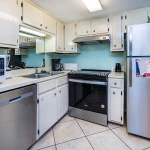 Kitchen area with white cabinetry, stainless appliances, and a breakfast bar with seating for a coastal dining adventure