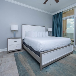 Rest in this inviting master bedroom featuring a king bed, soft decor, and beachfront balcony