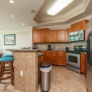 Prepare meals in this kitchen with elegant cabinetry, stainless appliances, and spacious countertops