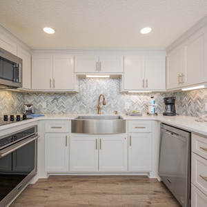 Modern kitchen features a spacious sink, modern cabinetry, and a stylish backsplash, creating an inviting cooking space