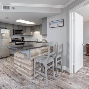 Gather around the stylish breakfast bar, perfect for enjoying coffee and conversation in this inviting kitchen space
