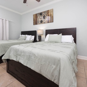 Rest comfortably in this inviting guest bedroom with two queen beds, soft linens, and tasteful decor