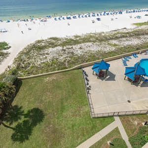 Overlooking the vibrant pool area, this view captures the lush greenery and the inviting beach just steps away