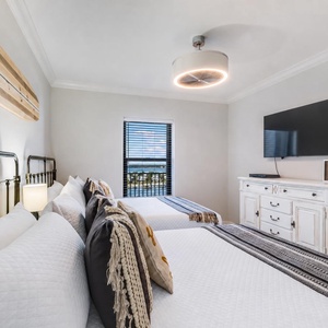 Relax in this inviting guest bedroom featuring two comfortable queen beds, stylish decor, and a view