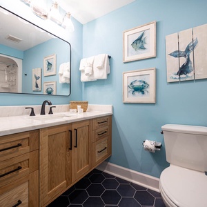 Refresh and rejuvenate in this cheerful guest bath, accented with coastal art and fun decor for a tranquil start