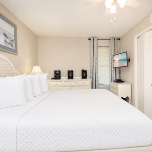 Comfortable master suite bedroom featuring a king bed, soft carpet, and a TV for your entertainment