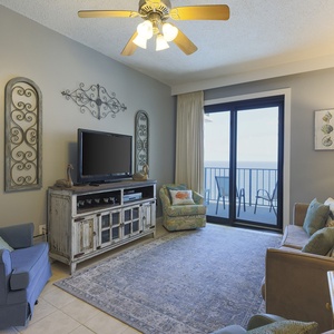 This inviting living area features a large TV, comfortable seating, and a lovely view from the balcony