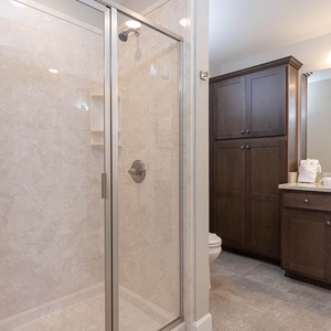 Enjoy a relaxing shower after a day at the beach in this guest bath with stylish cabinetry and spacious vanity