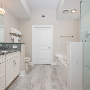 Experience relaxation in this master bath featuring a double vanity, a soaking tub, and a glass-enclosed shower
