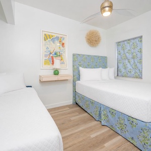 Guest bedroom featuring two beds, a double and twin daybed with trundle, with light and trendy accents